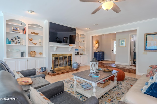 tiled living room with ceiling fan, ornamental molding, and built in features