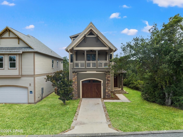 view of front of property featuring a balcony, a front lawn, and a garage