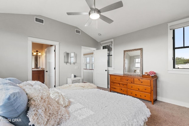 bedroom with lofted ceiling, ensuite bathroom, light carpet, and ceiling fan