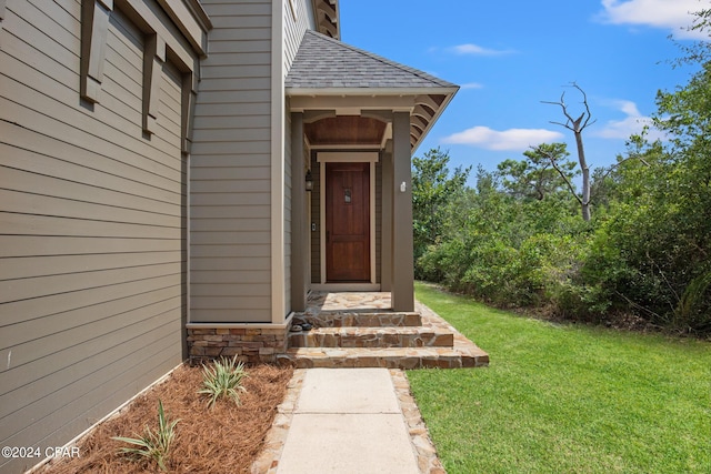 view of exterior entry featuring a yard