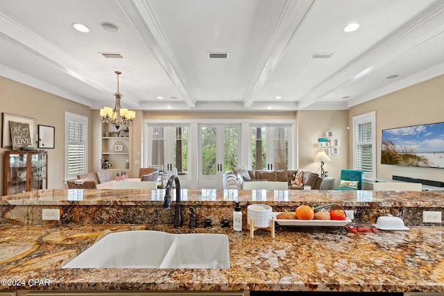 kitchen featuring crown molding, beam ceiling, sink, an inviting chandelier, and decorative light fixtures