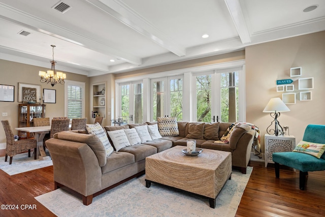 living room with ornamental molding, hardwood / wood-style flooring, built in shelves, a notable chandelier, and beam ceiling