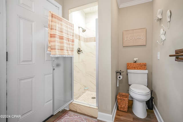 bathroom featuring toilet, wood-type flooring, a shower with door, and crown molding