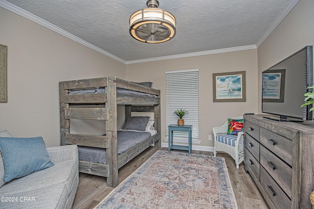 bedroom with crown molding, a textured ceiling, and light wood-type flooring