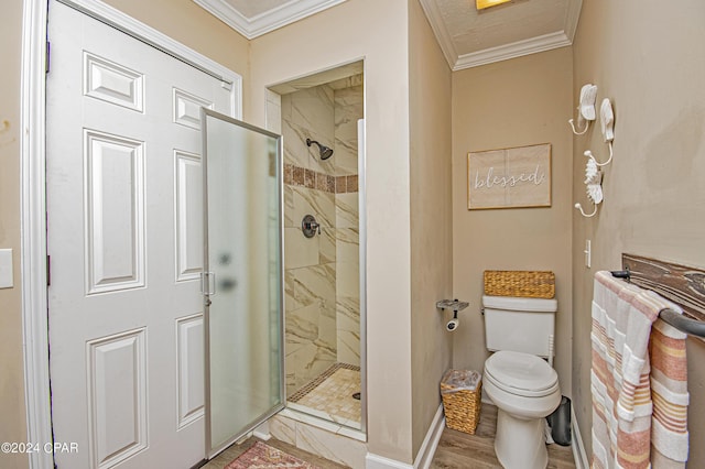 bathroom featuring hardwood / wood-style floors, toilet, a shower with shower door, and ornamental molding