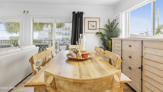 dining room featuring light hardwood / wood-style floors and crown molding