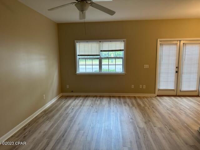 spare room with ceiling fan and light wood-type flooring