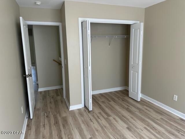 unfurnished bedroom featuring light hardwood / wood-style floors and a closet