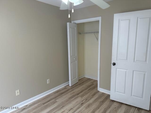 unfurnished bedroom with light wood-type flooring and a closet