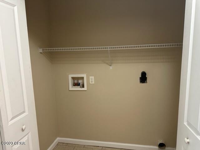 laundry area featuring hookup for a washing machine and light tile patterned floors