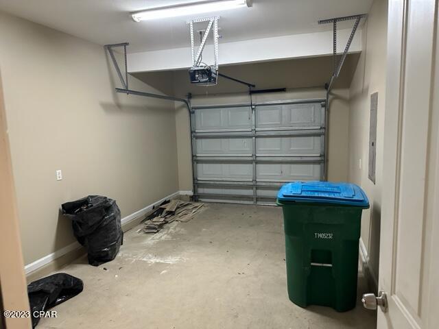 garage featuring electric panel and a garage door opener