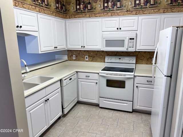 kitchen featuring white appliances, white cabinetry, sink, and light tile patterned floors