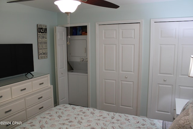 bedroom featuring multiple closets, a ceiling fan, and stacked washer / dryer