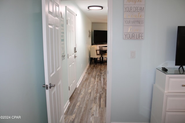 corridor with wood finished floors and baseboards