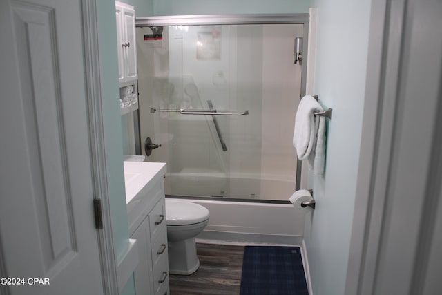 full bathroom featuring toilet, wood finished floors, vanity, and enclosed tub / shower combo