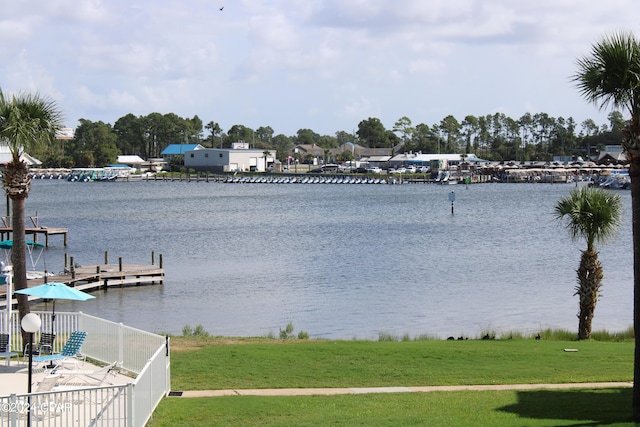 view of dock with a water view and a lawn