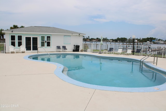 community pool with a patio area and fence