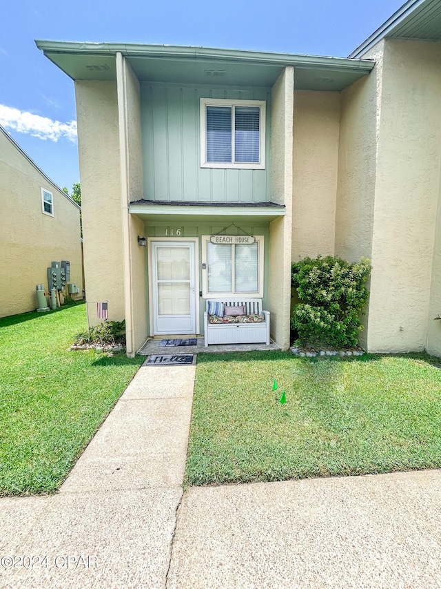 view of exterior entry featuring a yard