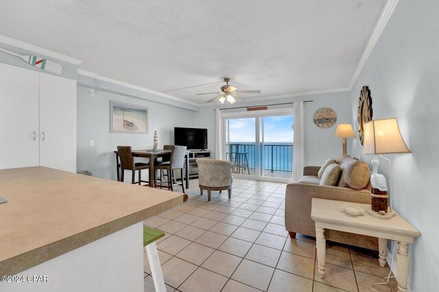 living room featuring ceiling fan, crown molding, and light tile patterned flooring