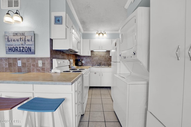 kitchen with backsplash, stacked washer and dryer, white cabinets, light tile patterned floors, and white electric range