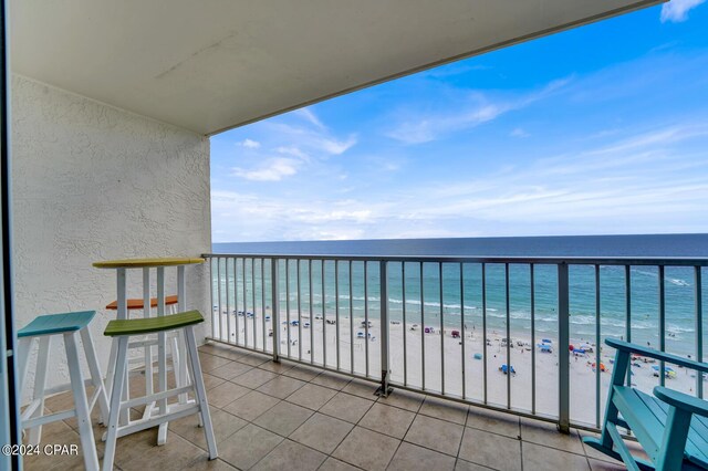 balcony featuring a beach view and a water view