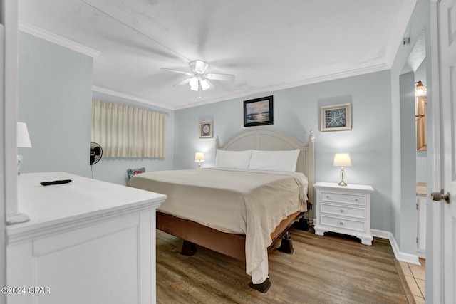 bedroom with ceiling fan, hardwood / wood-style floors, and ornamental molding