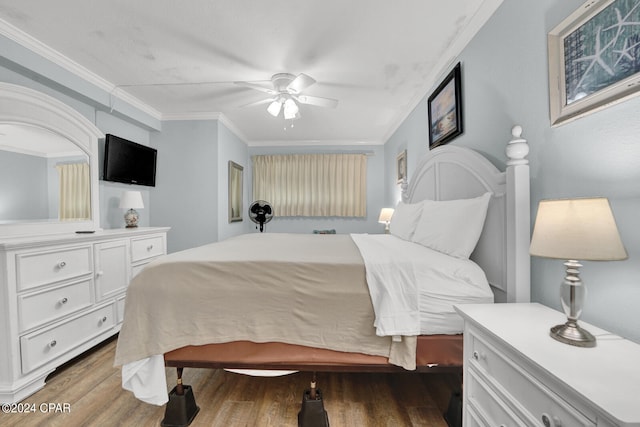 bedroom with ceiling fan, ornamental molding, and wood-type flooring