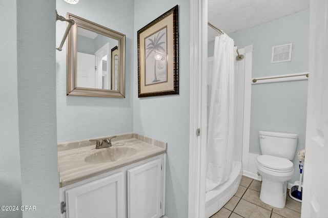 bathroom featuring tile patterned floors, a textured ceiling, vanity, and toilet