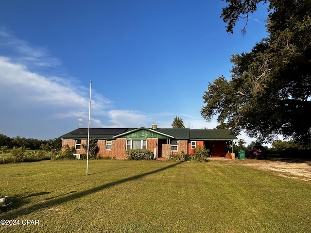 view of front of home with solar panels and a front yard