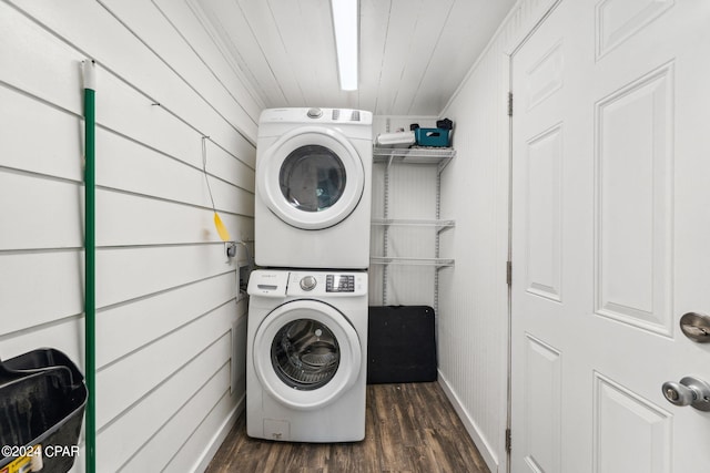 laundry room featuring dark hardwood / wood-style floors and stacked washer / dryer