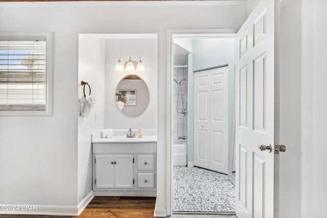 bathroom with tiled shower / bath, hardwood / wood-style floors, and vanity