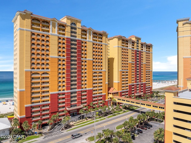 view of building exterior featuring a water view and a view of the beach