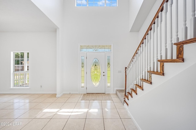 tiled entryway featuring a towering ceiling