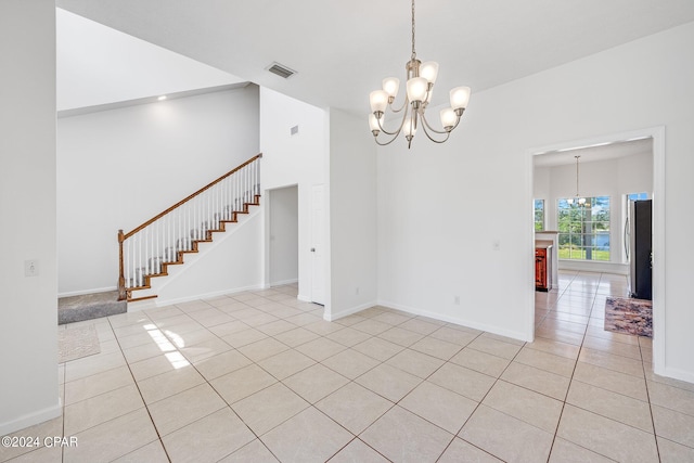 tiled empty room featuring a notable chandelier