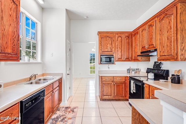 kitchen with sink, light tile patterned floors, and black appliances