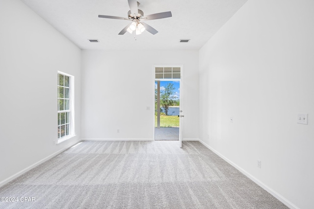 spare room featuring ceiling fan, carpet, and a healthy amount of sunlight