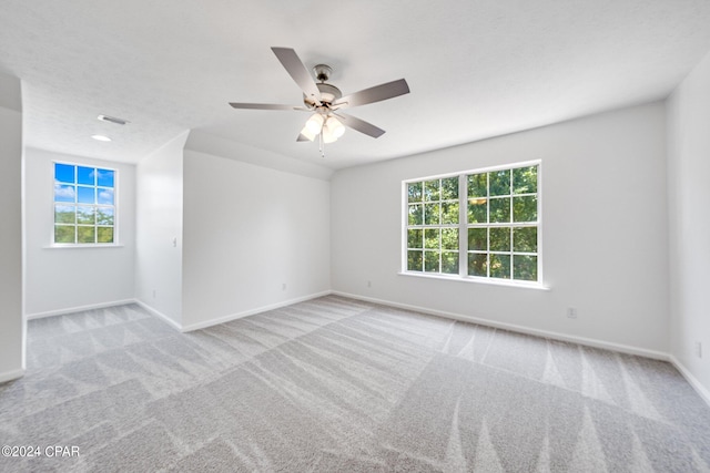 carpeted spare room featuring ceiling fan