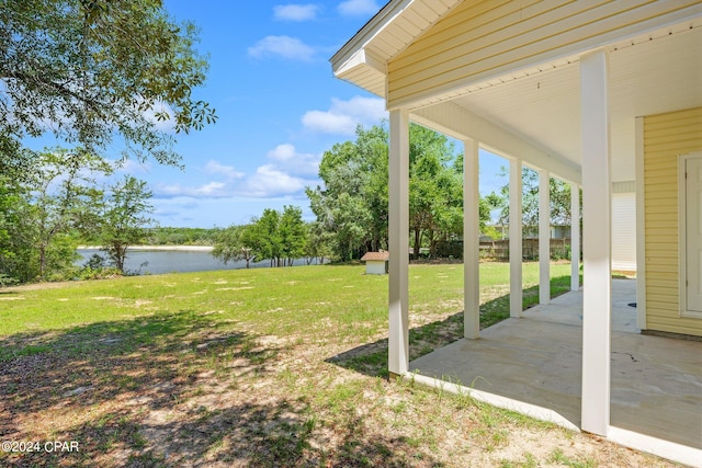 view of yard with a water view and a patio