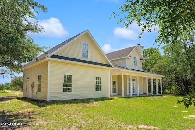 rear view of property with a yard