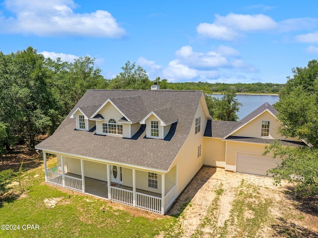 view of front of property featuring a garage, a porch, and a water view