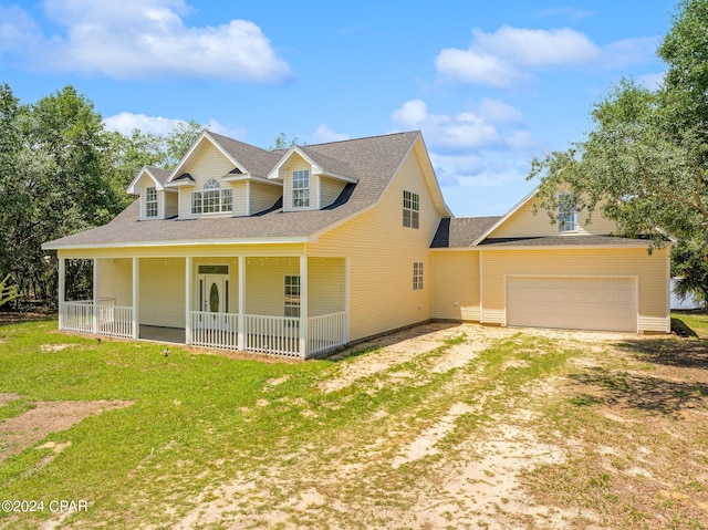 view of front of home with covered porch, a garage, and a front yard