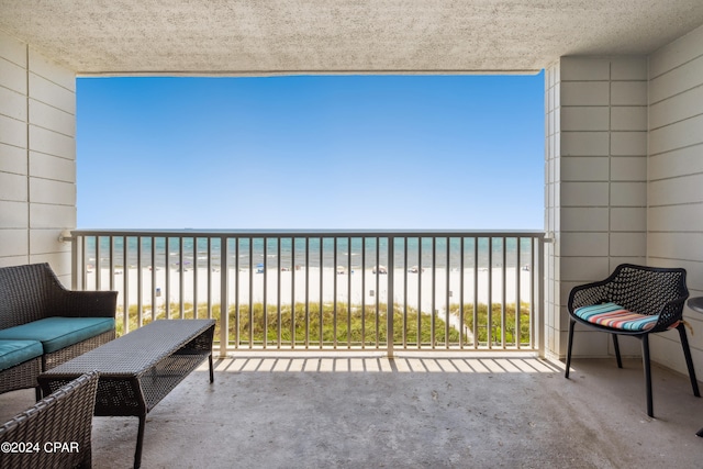 balcony featuring a beach view and a water view