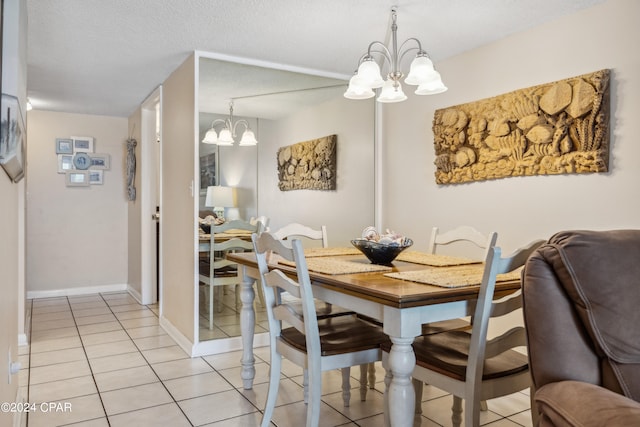 tiled dining room with a notable chandelier and a textured ceiling