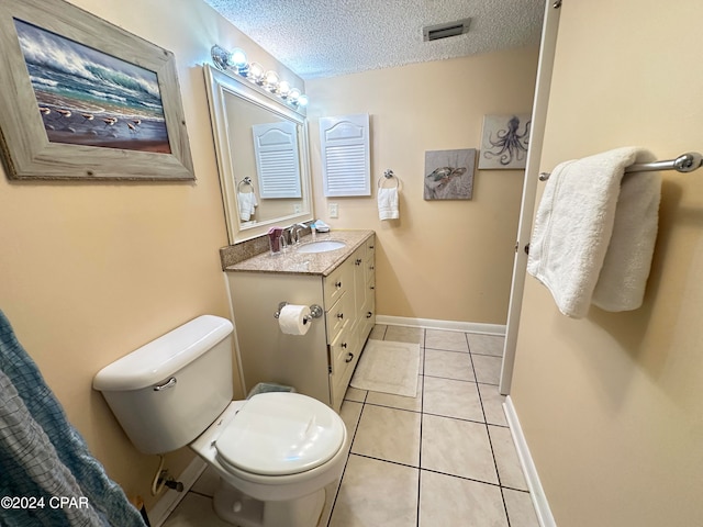 bathroom featuring vanity, tile patterned floors, a textured ceiling, and toilet