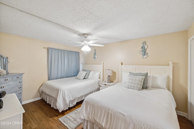 bedroom featuring dark wood-type flooring, a textured ceiling, and ceiling fan