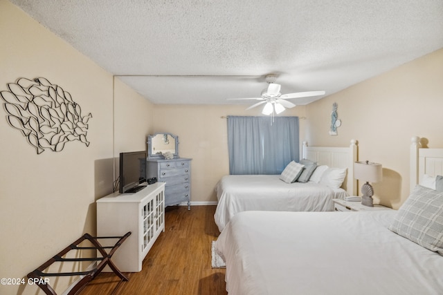 bedroom with a textured ceiling, hardwood / wood-style floors, and ceiling fan