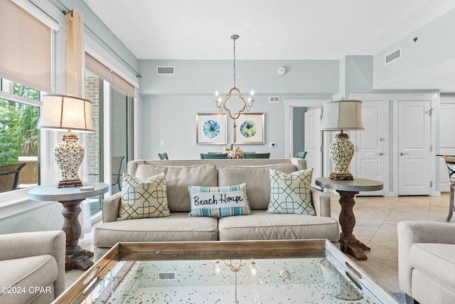 tiled living room featuring an inviting chandelier