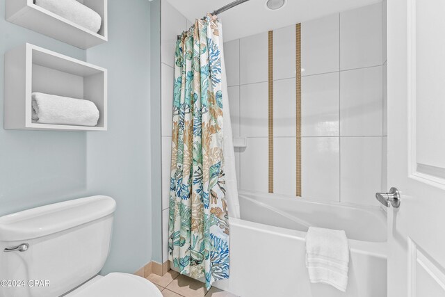 bathroom with tile patterned floors, shower / bathtub combination with curtain, and toilet