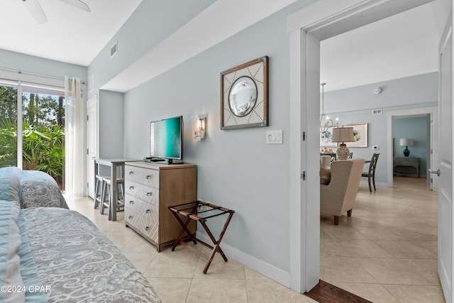 tiled bedroom featuring ceiling fan with notable chandelier