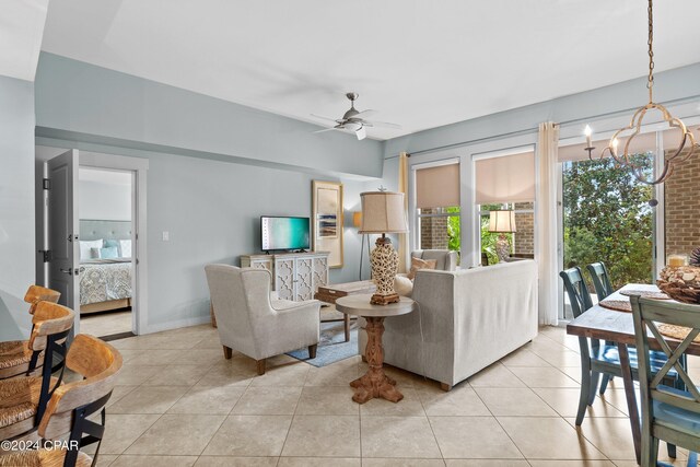 living room with light tile patterned floors and ceiling fan with notable chandelier